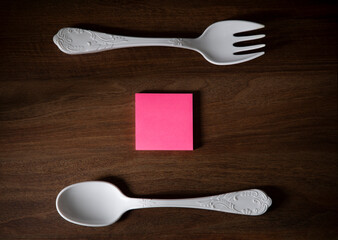 big plastic fork and spoon on dark wooden table