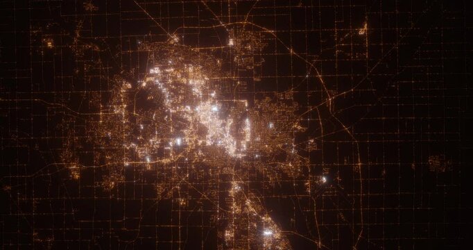 Fort Wayne (Indiana, USA) top view at night. Aerial view on modern city from space. Camera is flying above the city, moving forward. Vertical video. The north is on the left side