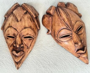 Pair of Handcrafted African Tribal Wooden Masks on Textured Background