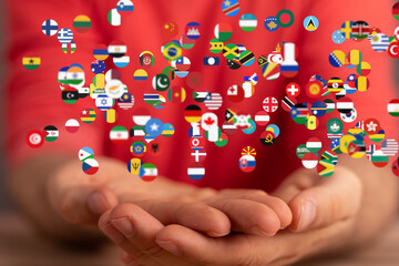 Image of hands gently cradling numerous flags, symbolizing global unity and connection.