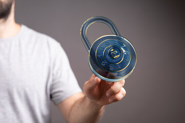 Image of a man holding a digital combination lock, representing cybersecurity and data protection.