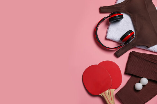 Sportswear, ping pong rackets, balls, towel and headphones on pink background, flat lay. Space for text - Powered by Adobe