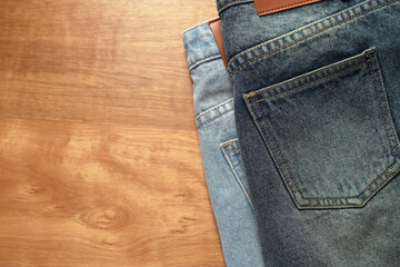 Jeans pants on the table wood background. back pocket of blue jeans, denim texture.