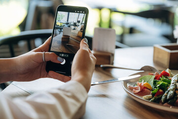With smartphone. Close up view of teenage girl that is sitting in the cafe restaurant