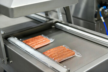 High-performance machines are wrapping processed fresh food products sausages. food production lines on conveyor belts, food production industry