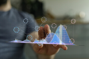 Stock photo of person interacting with a holographic graph showing data analysis and business growth.