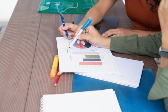 University students analyzing charts and graphs for project work - Powered by Adobe