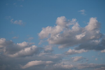 Fototapeta premium Bright cumulus clouds scattered across deep blue afternoon sky in fair weather