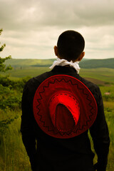 A woman holding an umbrella stands gracefully, the umbrella shielding her gently from the elements....