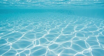 Obraz na płótnie Canvas Underwater view with turquoise water and sunlight beams creating rippling patterns on sandy bottom. Crystal clear aquatic environment with light reflections. Swimming concept