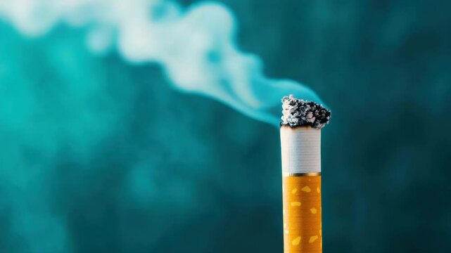 Burning cigarette with ash and smoke curling upwards on blue background, close up vdo showing tobacco product, filter, and nicotine details in vivid style for health awareness and caution
