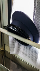 the official cap of the train conductor on the window 