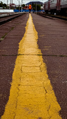 A railway worker walks along the platform along the yellow stripe