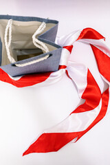 Stylish Composition of a Blue Denim Shopping Bag and a Vibrant Red and White Scarf
