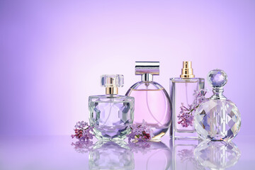 Bottles of perfume and lilac flowers on mirror surface against violet gradient background, space...