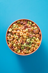 Colorful cereal bowl on blue background for breakfast concept