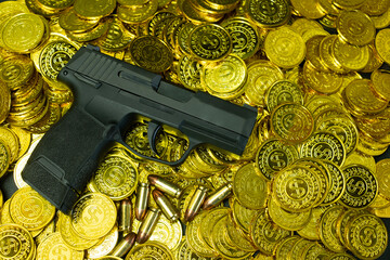Handgun with bullets 9mm on a stack of gold coins