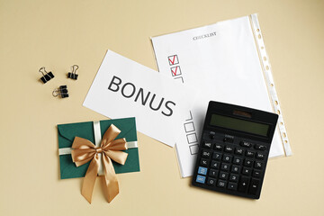 Card with word Bonus, envelope, binder clips, calculator and checklist on beige background, flat lay