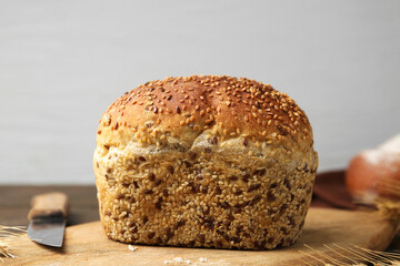 Freshly baked bread with seeds on table against grey background, closeup