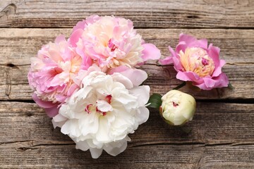 Beautiful peonies on wooden table, flat lay