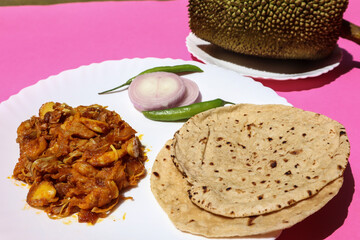 Comforting Roti aur Sabji with raw onion aur green chilly salad on white plate. Kathal ki sabji aur chapati