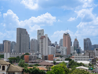 Fototapeta premium A bustling economic cityscape filled with towering skyscrapers, set beneath a bright sky with uniquely charming clouds. City of commercial, wealth and richness.