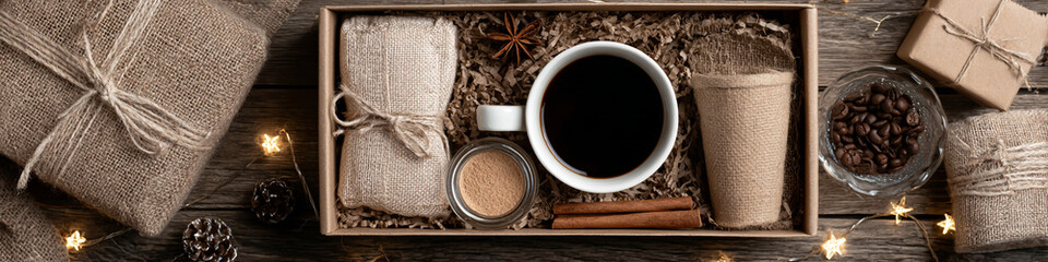 A rustic coffee gift set with burlap wrapped items and star shaped lights on a wooden surface seen from above