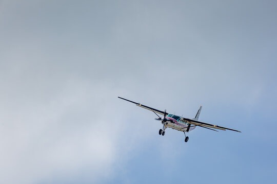 Aircraft coming into land, Image shows a light aircraft used for skydiving with a slight roll to line up with the runway and a cloudy background