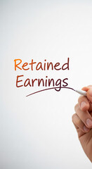 Handwriting shows "Retained Earnings" on white background, illustrating financial concept of profit reinvestment for growth