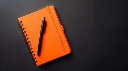 Orange Notebook and Pen: A vibrant orange notebook with a black pen rests on a dark gray surface, creating a minimalist yet striking image perfect for representing organization, planning.
