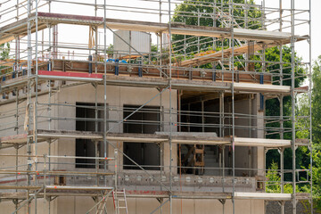 Scaffold around a concrete building. Reinforcement bars can be seen inside.