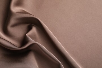 Crumpled light brown silk fabric as background, top view