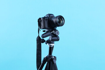 Professional video camera on light blue background