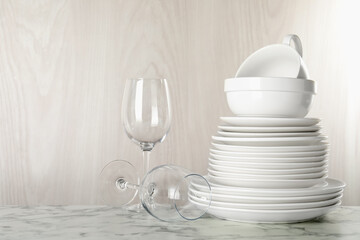 Different clean dishware on white marble table indoors