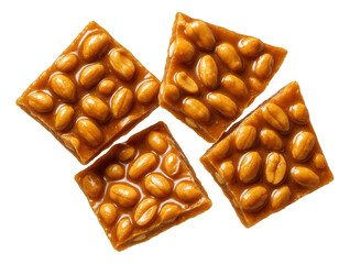 Four pieces of peanut brittle with whole peanuts embedded in a caramelized sugar base.
