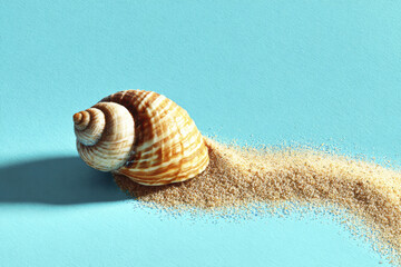 Single seashell resting on smooth turquoise surface with trail of fine sand behind it, creating peaceful and natural beach inspired scene