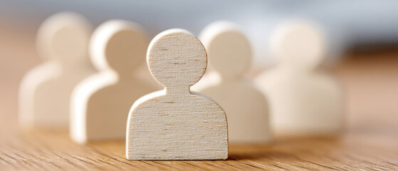 Human figures representing teamwork and collaboration on wooden table focused content type indoor environment close-up viewpoint concept of community engagement