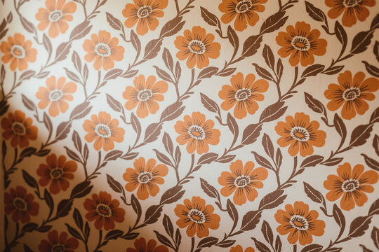 Fototapeta Vintage 70s floral wallpaper pattern with muted orange and brown tones, evoking a groovy retro aesthetic. Ideal for nostalgic design projects, posters, and social media visuals.