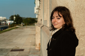 Woman leaning on wall with confident and serious gaze