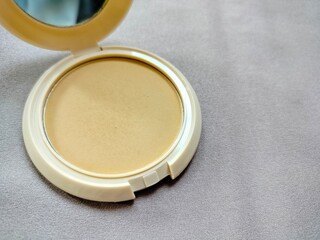 cosmetic packing compact powder with glass on grey background