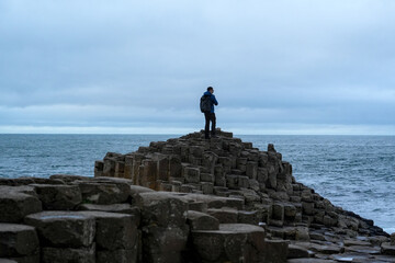 Person exploring Giant's Causeway, Ana of Hexagonal Basalt Stones, Created by Ancient Volcanic...