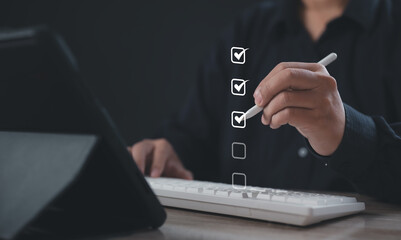 Businessman using a digital pen to tick checklist boxes on a virtual interface, representing task completion, productivity tracking, goal achievement, and digital workflow efficiency in modern work.