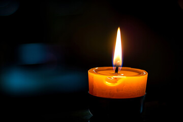 single candle flame in dark background, glowing warm light Strong symbol of hope, memory and faith.