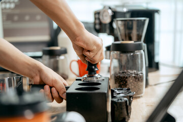 A young Asian male barista, dressed in a striped apron, skillfully creates beautiful latte art in a cozy, modern cafe, professional coffee equipment and takeaway cups.