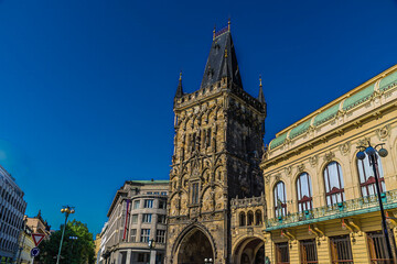 A view past ornate buildings towards the Powder Tower  in central Prague in springtime