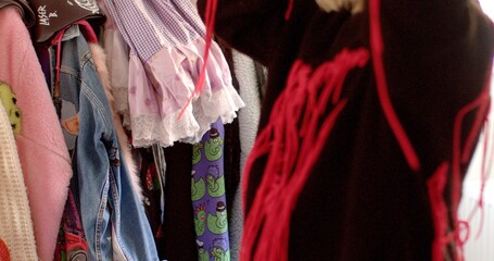 A clothing rack is beautifully displaying a wide variety of garments in an array of different...