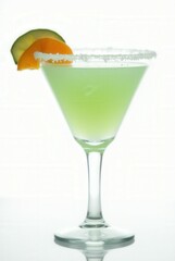 Green Apple Martini: A refreshing green apple martini garnished with a lime and apple slice, its rim dusted with sugar. The perfect cocktail for a sophisticated evening.