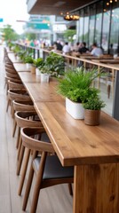 Obraz premium Enjoying the ambiance at an outdoor cafe featuring wooden tables adorned with fresh plants in a lively city environment
