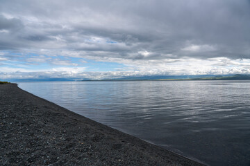 Obraz premium Dramatic Clouds Over a Calm Mountain Lake