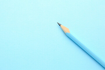 One graphite pencil on light blue background, top view. Space for text